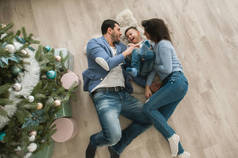 早晨的圣诞节快乐的家庭一起躺在地板上。家庭幸福和幸福的概念.