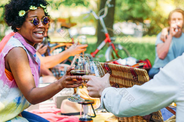 快乐的年轻朋友欢呼与红酒眼镜在乡村野餐烧烤聚会上-非洲嬉皮士妇女有乐趣和笑户外-友谊和青年假期生活方式的概念