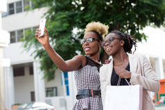 两个快乐的女商人在外面用智能手机自拍