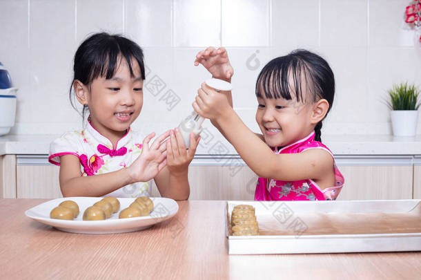 亚洲华人小姐妹在家厨房做月饼