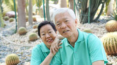 亚洲老年夫妇一起在绿色自然公园的背景下欢笑