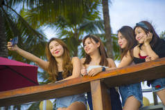 集团的生活方式肖像与年轻的快乐和迷人的亚洲华人和韩国妇女闲逛, 女朋友享受假日旅行在热带度假胜地带自拍图片与手机 
