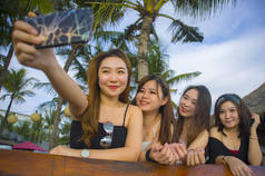 集团的生活方式肖像与年轻的快乐和迷人的亚洲华人和韩国妇女闲逛, 女朋友享受假日旅行在热带度假胜地带自拍图片与手机 