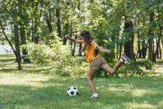 儿童在公园踢足球的侧面视图