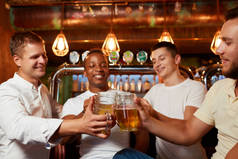 四朋友在舒适的酒吧里举杯庆祝他们的友谊.