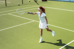 年轻女子网球运动员在太阳镜打网球在法院