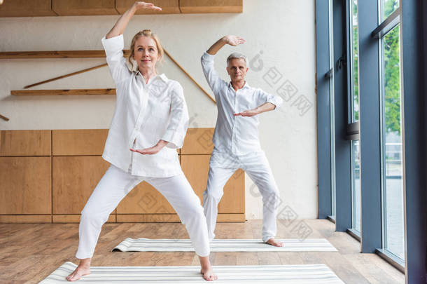 运动的资深夫妇在瑜伽垫上练习瑜伽