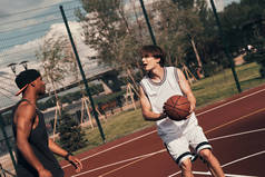 两名运动员在户外篮球竞技场上打篮球