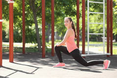 运动的年轻妇女训练在运动场室外