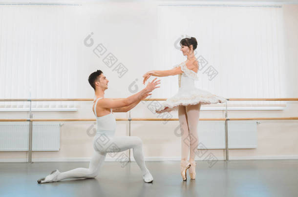 专业的, 情感的芭蕾舞演员练习在健身房或大厅与简约的内部。情侣跳舞前的感官舞蹈表演.