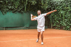 英俊的运动员打网球与球拍网球场
