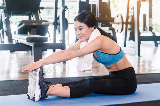 妇女伸展腿热身运动在健身健身房