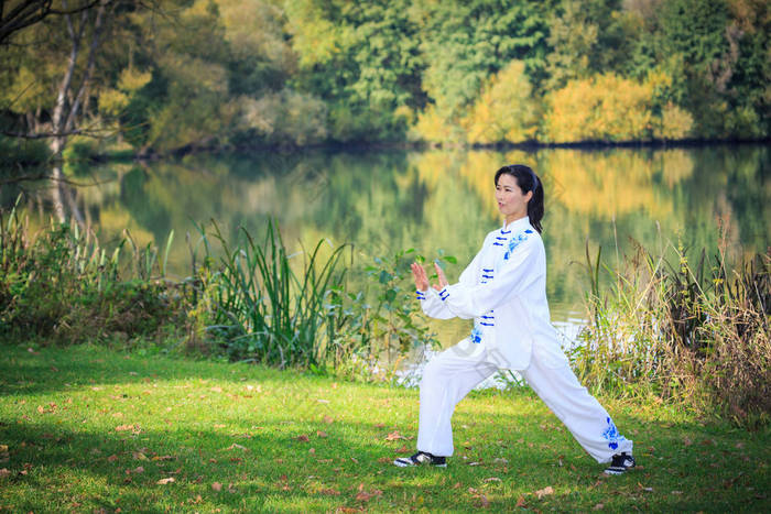 在湖上做太极或齐功运动的年轻女子 太极拳