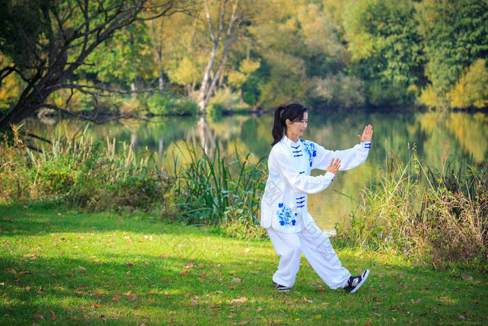 在湖上做太极或齐功运动的年轻女子 太极拳