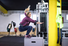 运动女子训练跳上健身箱在交叉健身房