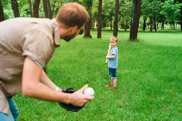 父亲和儿子在公园打棒球