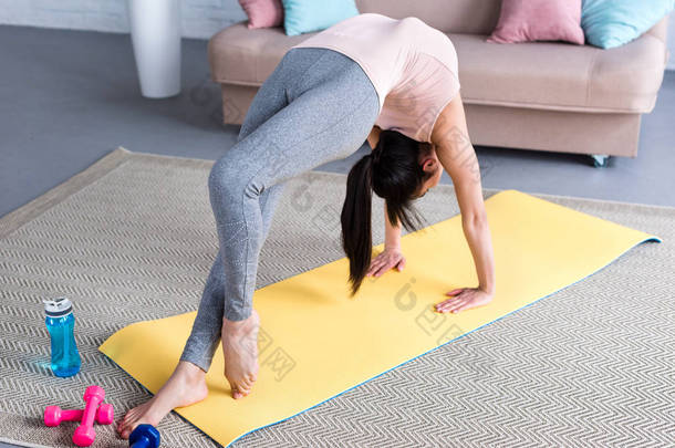 美丽的年轻女子准备一条<strong>腿</strong>轮瑜伽姿势 (Eka Pada Urdhva Dhanurasana) 在家