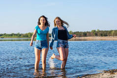 朋友们在海边跳舞, 溅水, 大笑。Tw