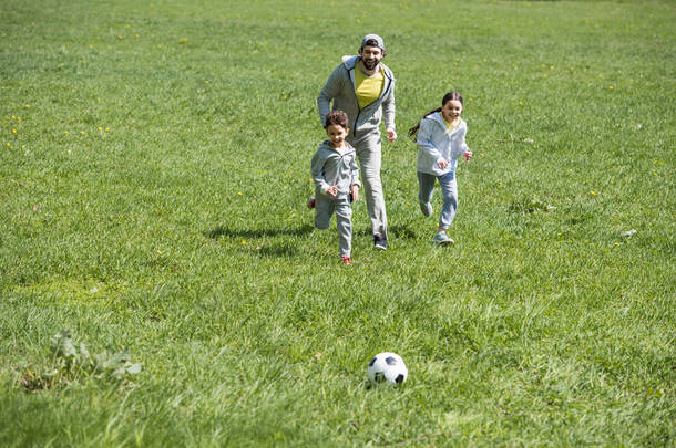 快<strong>乐</strong>的<strong>运动</strong>家庭在草地上踢足球 