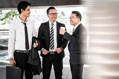 一组商务同事在会议咖啡歇期间聊天。亚洲商界男士站在办公楼前聊天.