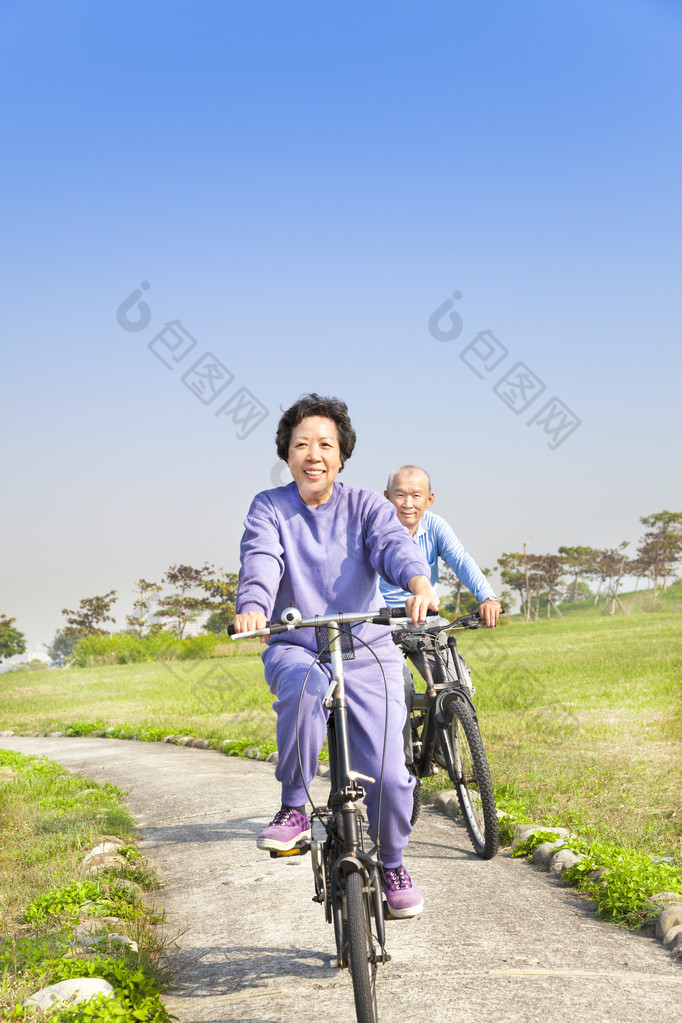 亚洲老年人情侣在公园里骑自行车