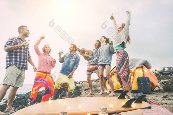 快乐的朋友跳舞和乐趣在露营地做一个海滩派对--年轻人在野营时笑着喝啤酒, 旅行, 度假, 生活方式的概念