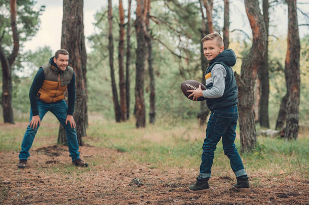 父亲和儿子玩球在森林里