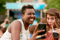 不同群体的两个女孩在夏季音乐节的人群拍照拍照