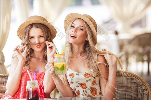 两个幸福美丽的女孩在一家<strong>咖啡</strong>馆里阳光灿烂的夏天 d 开心