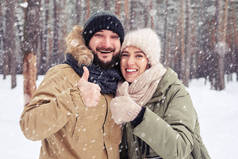 微笑对夫妇显示 ok 手势下在神秘岛的降雪