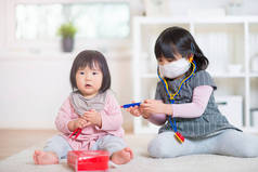 两个快乐的日本姐妹玩医疗设置在家里