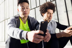两个适合男女运动勇在城市中使用手机.