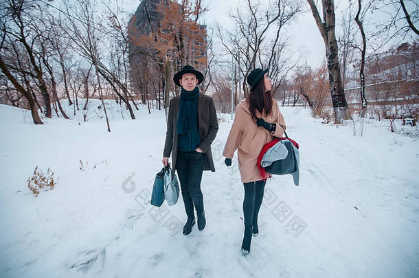 年轻的时髦漂亮夫妇戴着黑帽子在冬天的森林里，爱，在山里的<strong>寒假</strong>，