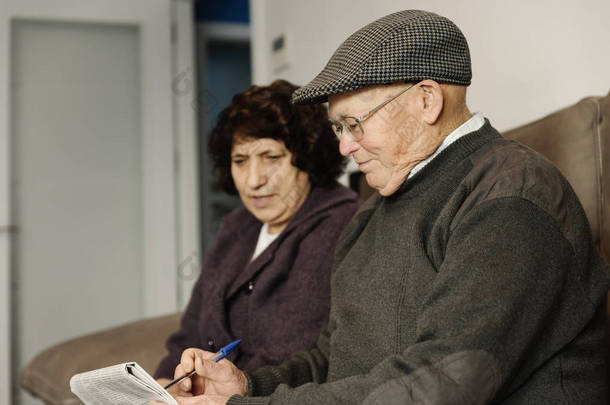 老年夫妇看报纸.