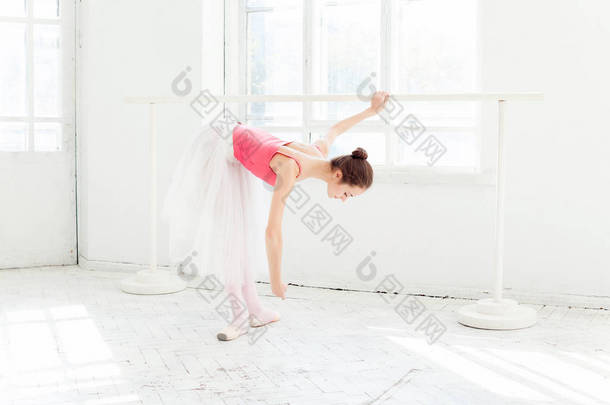 芭蕾舞女演员摆足尖鞋在白色的木制凉亭