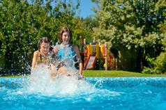 夏季健身，孩子在游泳池中的开心，微笑女孩飞溅在水中的，儿童家庭度假