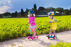 在阳光明媚的夏日骑着滑板车的孩子