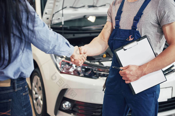 丈夫、汽车修理工和女顾客就修理汽车达成协议.