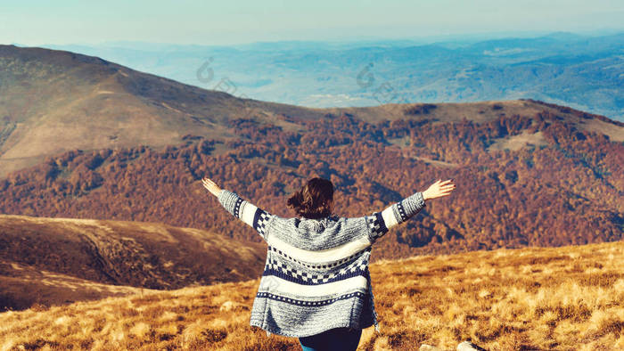 快乐的女人在山顶张开双手。自由和健康的生活方式。美丽的秋天风景. 