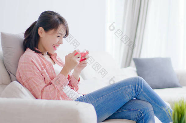 漂亮的女人通过电话玩手机游戏，在<strong>家里</strong>很开心