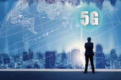 5g 网络无线系统和物联网与成功的商人站在建筑物的顶部和通过城市景观天际线夜景灯光, 连接全球无线设备.