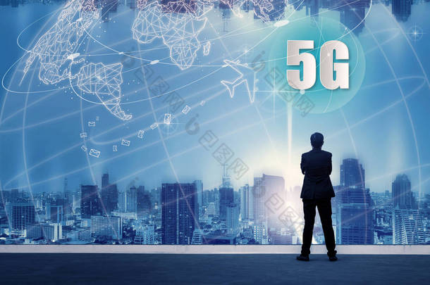 5g 网络无线系统和物联网与成功的商人站在建筑物的顶部和通过城市景观天际线夜景灯光, 连接全球无线设备.