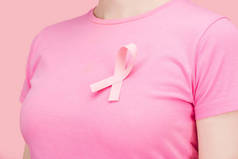 特写：穿粉红色T恤的妇女与乳腺癌唱隔离在粉红色