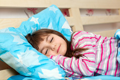 漂亮的小女孩睡在床下蓝色毯子