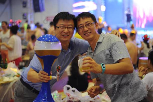 --资料图片：2015年6月27日，在中国东北黑龙江省哈尔滨市举行的哈尔滨国际啤酒节上，人们享用啤酒