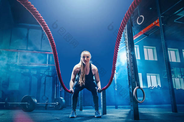 女子用战斗绳索战斗绳索锻炼在健身健身房.