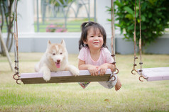 亚洲宝贝宝贝与小狗的秋千上