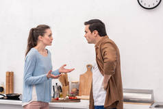 成人夫妇在厨房吵架的侧面视图