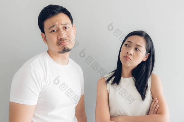 悲伤的夫妇情人在白色 t恤和灰色背景.