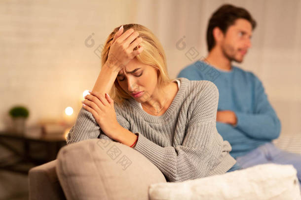 沮丧的女人坐在男人旁边后，在家里争吵